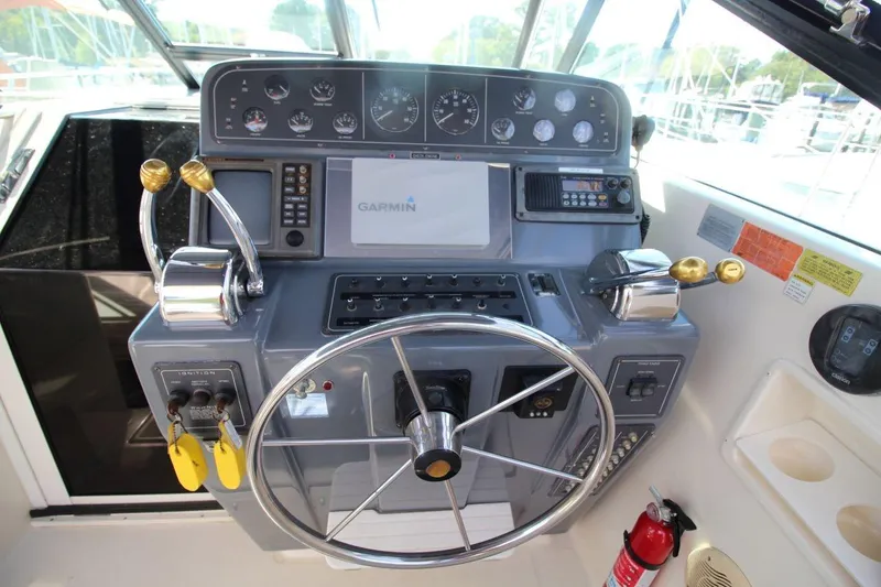 Slide: The Image of 1996 Tiara Yachts 3300 Open helm with Garmin navigation, gauges, and controls. - 17