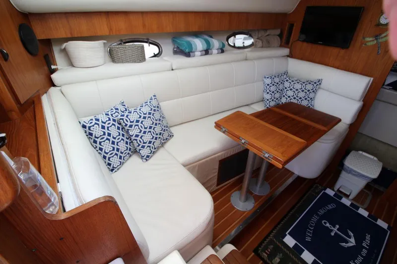 Slide: The Image of Interior of 1996 Tiara Yachts 3300 Open with white seating and wooden table. - 19