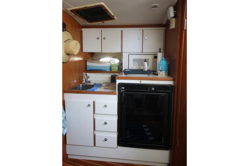 Slide: The Image of 1996 Tiara Yachts 3300 Open galley with cabinets, sink, and appliances. - 20