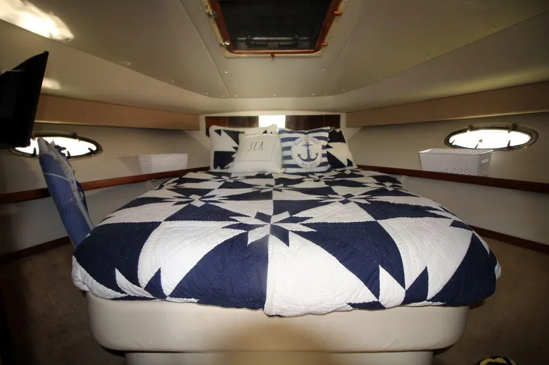 Slide: The Image of 1996 Tiara Yachts 3300 Open cabin with nautical-themed bedding and porthole windows. - 21