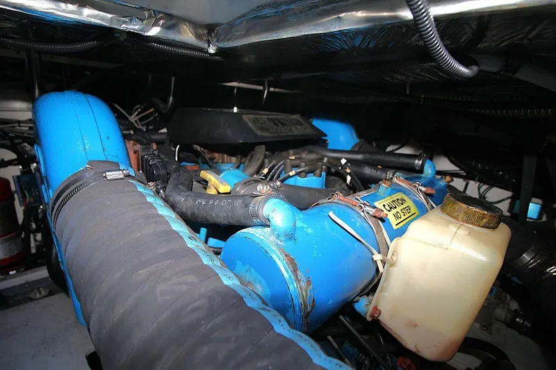 Slide: The Image of Engine compartment of a 1996 Tiara Yachts 3300 Open, featuring blue components and hoses. - 25