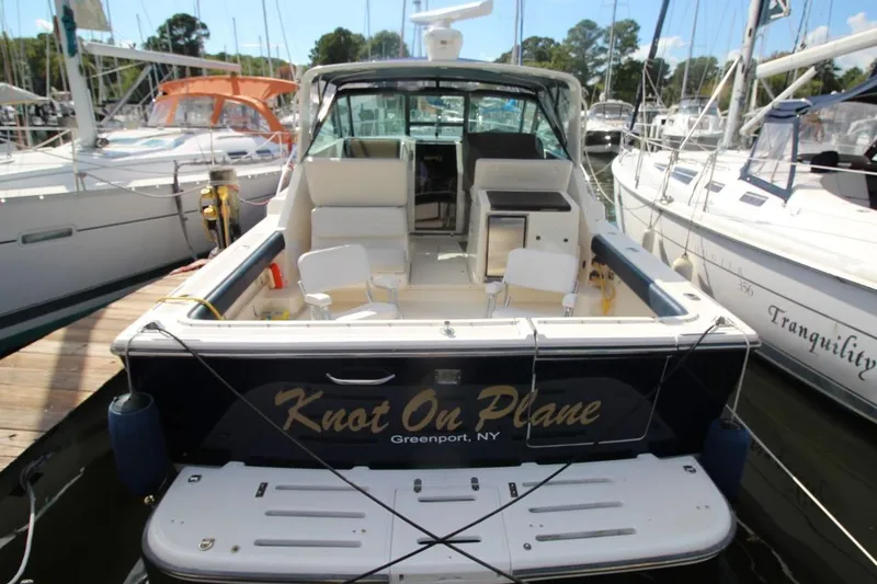 Slide: The Image of 1996 Tiara Yachts 3300 Open docked, rear view with "Knot On Plane" name visible. - 3