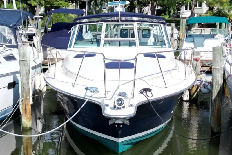 Slide: The Image of 1996 Tiara Yachts 3300 Open docked among other boats in a marina. - 4