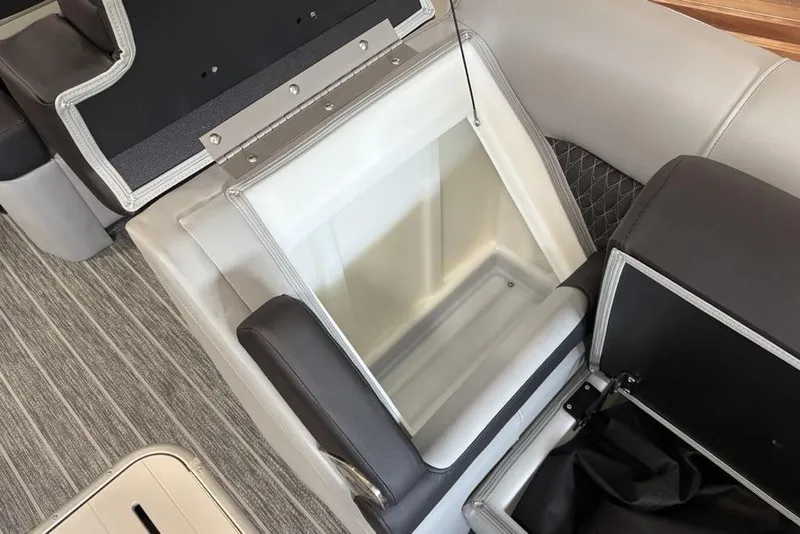 Slide: The Image of 2026 Premier 250 Solaris RS CL boat seat storage compartment, open with visible interior. - 11
