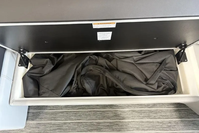 Slide: The Image of Open storage compartment in 2026 Premier 250 Solaris RS CL boat, containing black fabric. - 14
