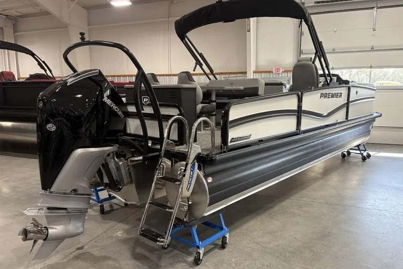 Slide: The Image of 2026 Premier 250 Solaris RS CL pontoon boat with Mercury outboard engine in showroom. - 2