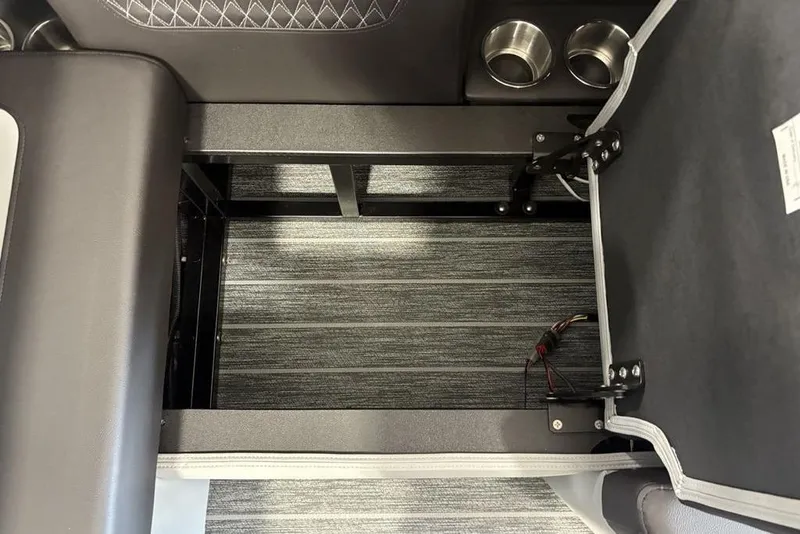 Slide: The Image of Open storage compartment in 2026 Premier 250 Solaris RS CL boat, featuring cup holders and wiring. - 28