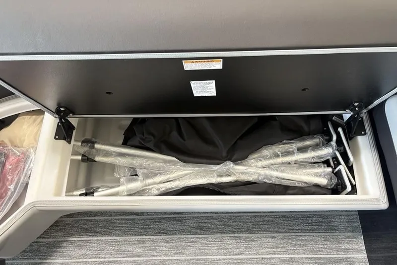 Slide: The Image of Storage compartment in 2026 Premier 250 Solaris RS CL boat, containing wrapped metal poles. - 5