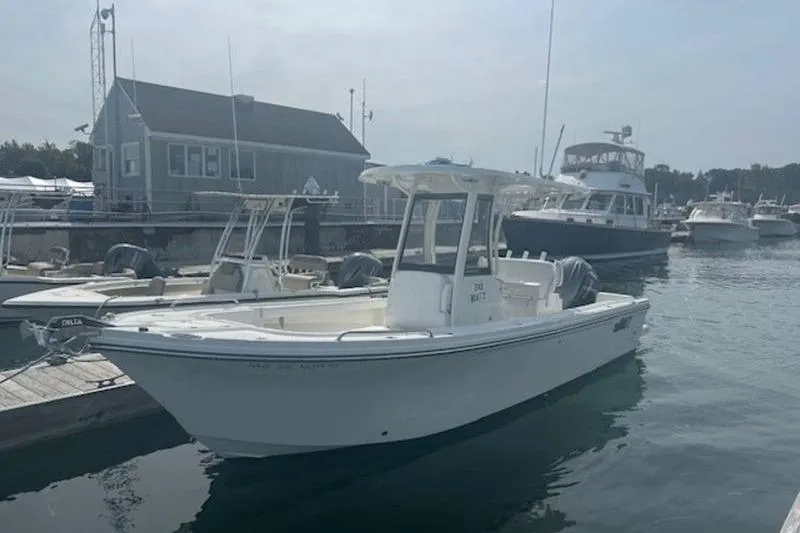 Slide: The Image of 2025 Parker 2400 Center Console boat docked at a marina, surrounded by other vessels. - 1