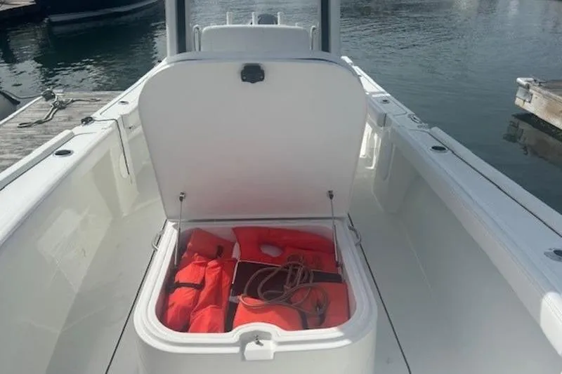 Slide: The Image of 2025 Parker 2400 Center Console boat with open storage compartment containing life jackets. - 13