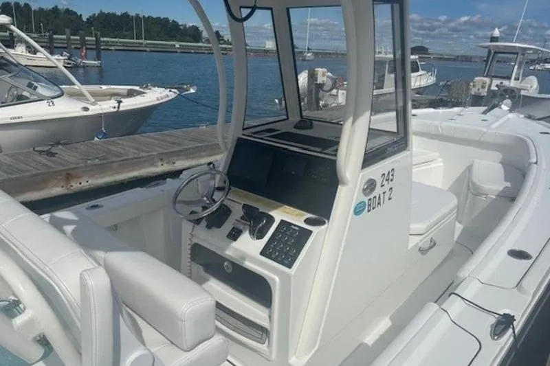 Slide: The Image of 2025 Parker 2400 Center Console boat docked, featuring modern controls and spacious seating. - 19