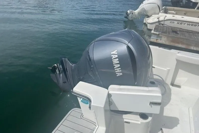 Slide: The Image of 2025 Parker 2400 Center Console with Yamaha outboard motor docked on calm water. - 4