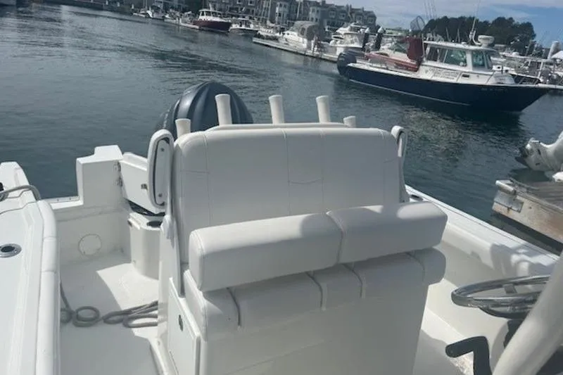 Slide: The Image of 2025 Parker 2400 Center Console boat docked in a marina, featuring white seating and steering. - 6