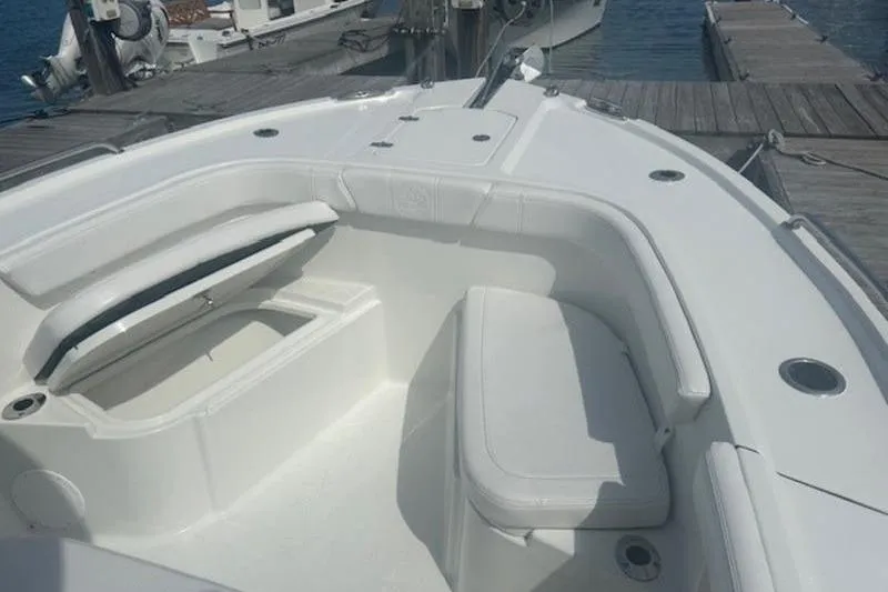 Slide: The Image of 2025 Parker 2400 Center Console boat interior with seating and storage, docked at marina. - 9