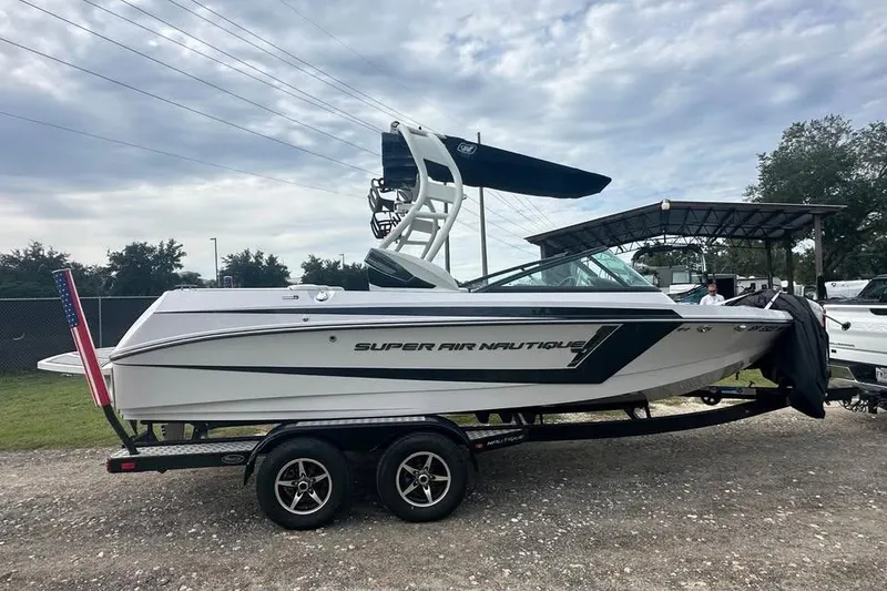 Slide: The Image of 2015 Nautique Super Air Nautique 210 boat on trailer, parked outdoors. - 1