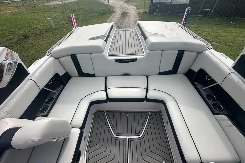 Slide: The Image of 2015 Nautique Super Air Nautique 210 interior with white seating and sleek design. - 10
