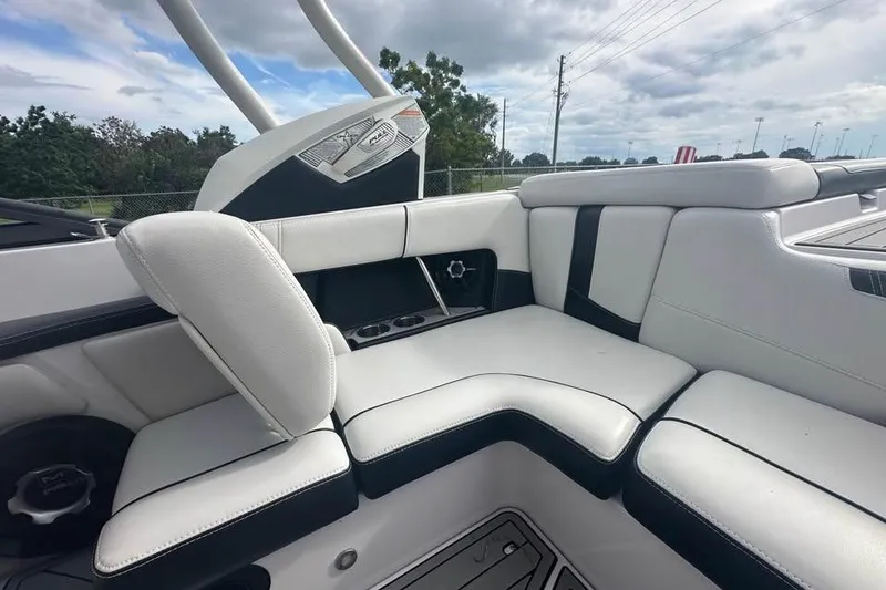 Slide: The Image of 2015 Nautique Super Air Nautique 210 interior with white leather seating and cup holders. - 12