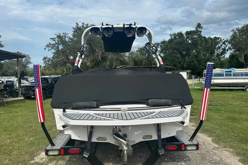 Slide: The Image of 2015 Nautique Super Air Nautique 210 boat with American flag accents, rear view. - 3