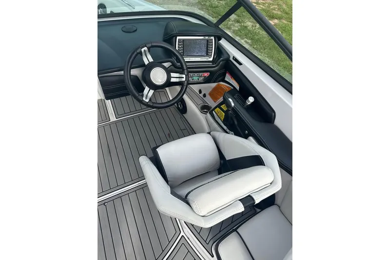 Slide: The Image of 2015 Nautique Super Air Nautique 210 cockpit with steering wheel and control panel. - 8