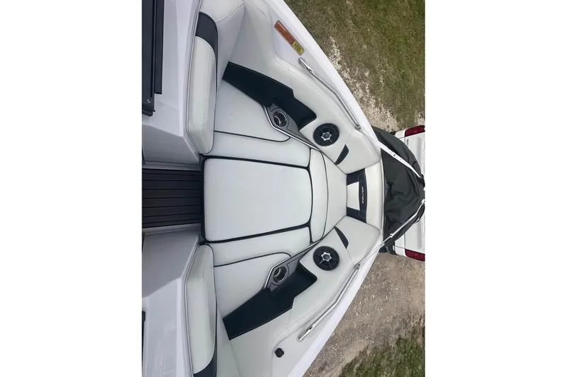 Slide: The Image of 2015 Nautique Super Air Nautique 210 boat interior with white and black seating. - 9