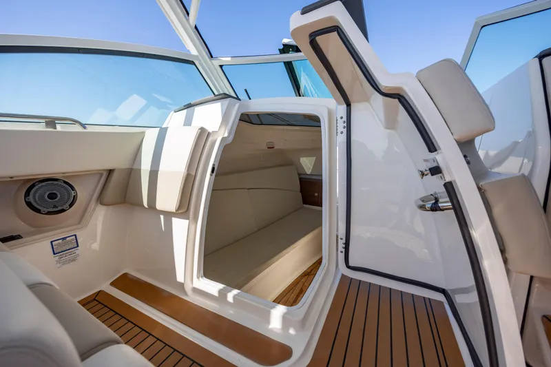 Slide: The Image of 2023 Boston Whaler 320 Vantage cabin interior with seating and wood flooring. - 13