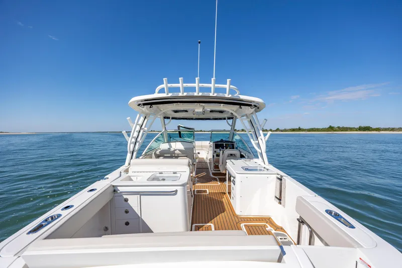 Slide: The Image of 2023 Boston Whaler 320 Vantage boat on calm water, showcasing spacious deck and seating. - 18