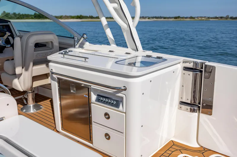 Slide: The Image of 2023 Boston Whaler 320 Vantage boat interior with sleek kitchen and seating area. - 23