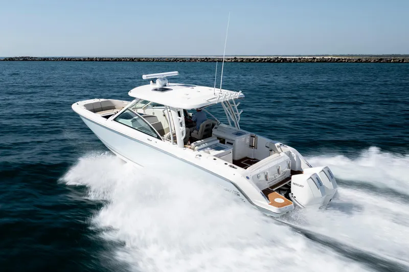 Slide: The Image of 2023 Boston Whaler 320 Vantage cruising on open water, showcasing sleek design and powerful engines. - 46