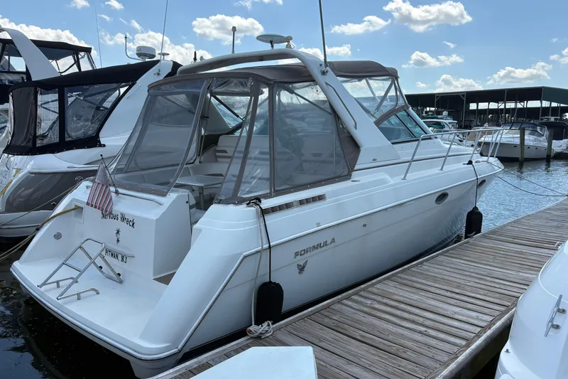 The Image of 2000 Formula 34 Performance Cruiser docked at marina under blue sky. - 1