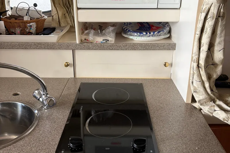 Slide: The Image of Compact kitchen area in a 2000 Formula 34 Performance Cruiser with stove and sink. - 12
