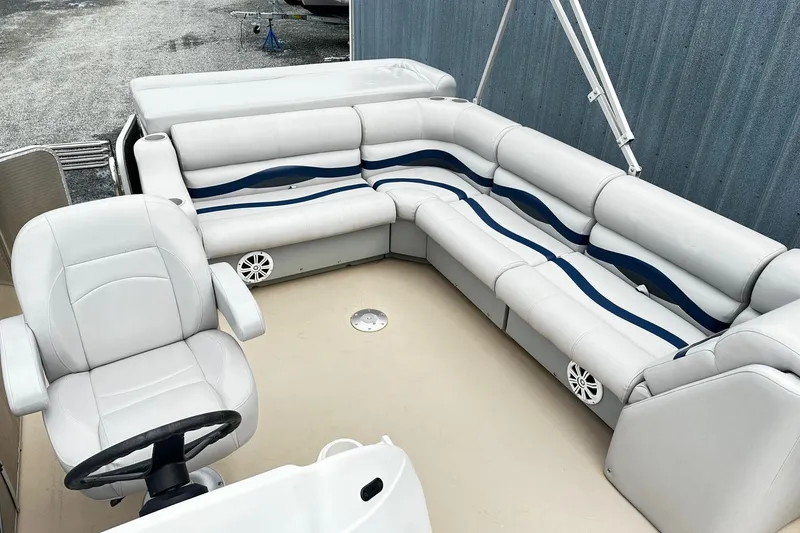 Slide: The Image of 2007 Godfrey Sweetwater Tuscany pontoon boat interior with plush seating and steering console. - 5