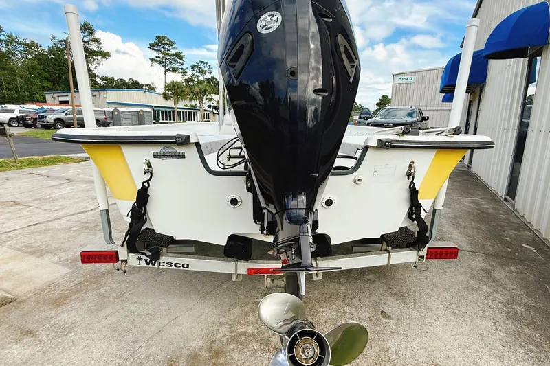 Slide: The Image of 2005 Nitro Bay boat on trailer with outboard motor, parked outdoors. - 11