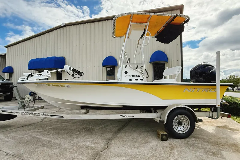 Slide: The Image of 2005 Nitro Bay boat on trailer, yellow and white, parked outside a building. - 3