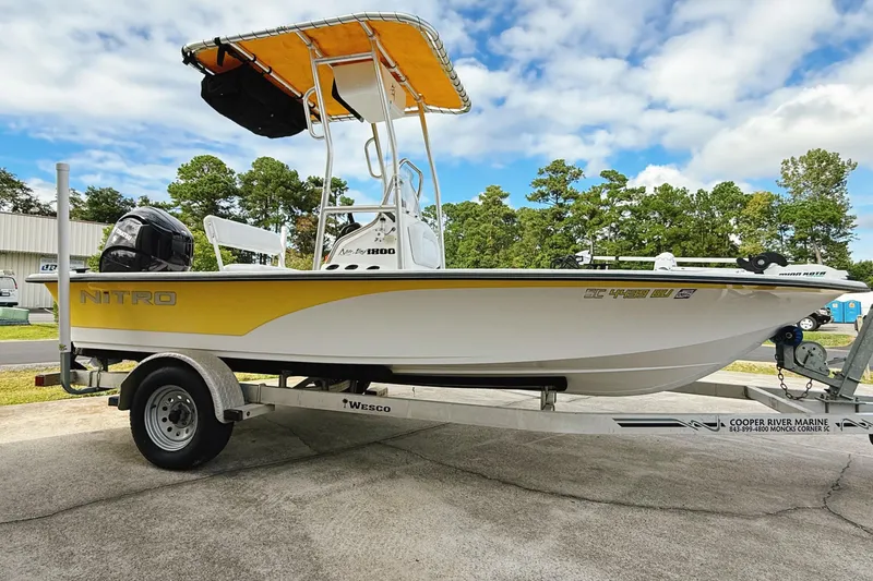 Slide: The Image of 2005 Nitro Bay boat on trailer, yellow and white design, parked outdoors. - 4