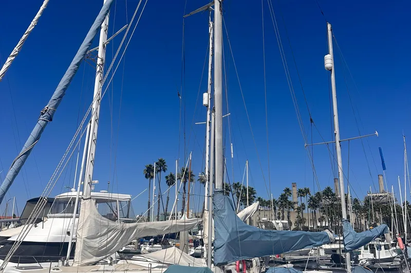 Slide: The Image of Sailboats docked at marina under clear blue sky, featuring a 1978 Pearson 424. - 11