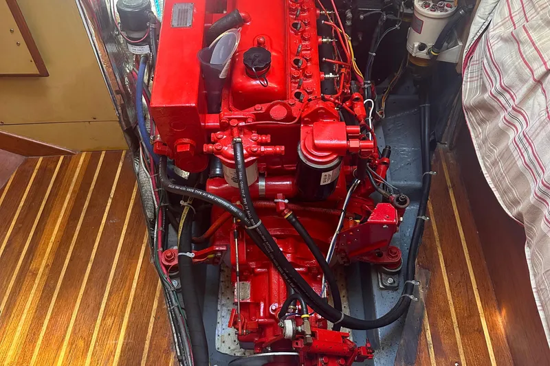 Slide: The Image of Red engine inside a 1978 Pearson 424 sailboat, surrounded by wooden flooring. - 19