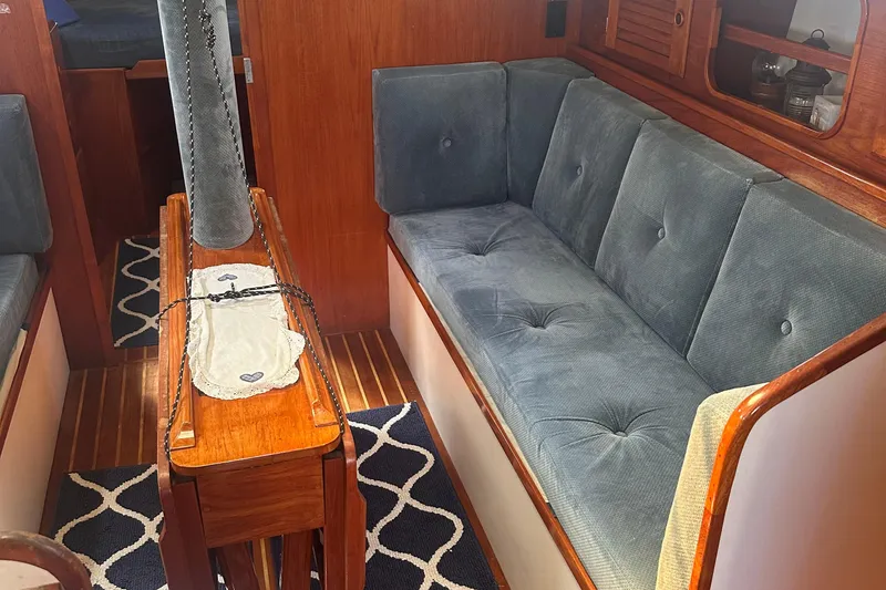 Slide: The Image of Interior of a 1978 Pearson 424 sailboat with blue cushioned seating and wooden accents. - 24