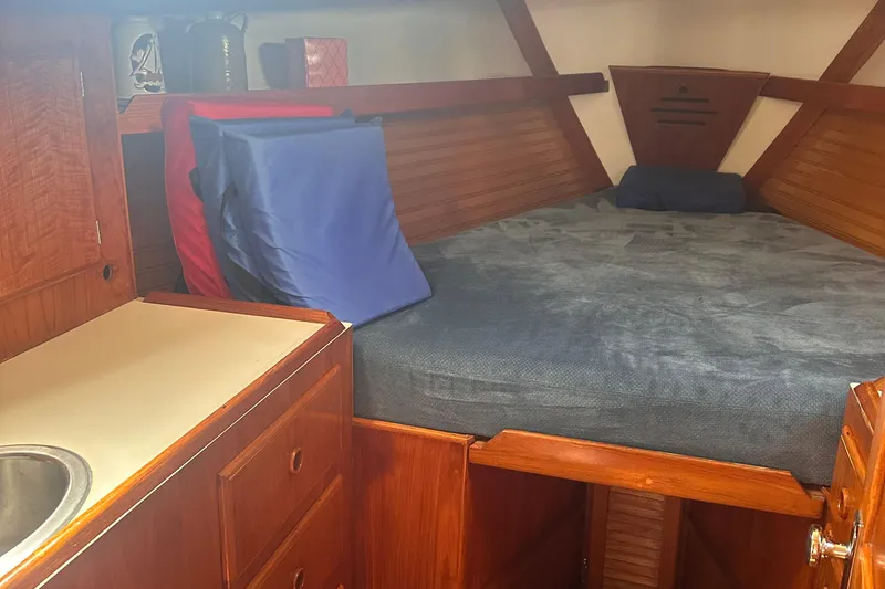 Slide: The Image of 1978 Pearson 424 sailboat cabin with cozy bed and wooden cabinetry. - 4
