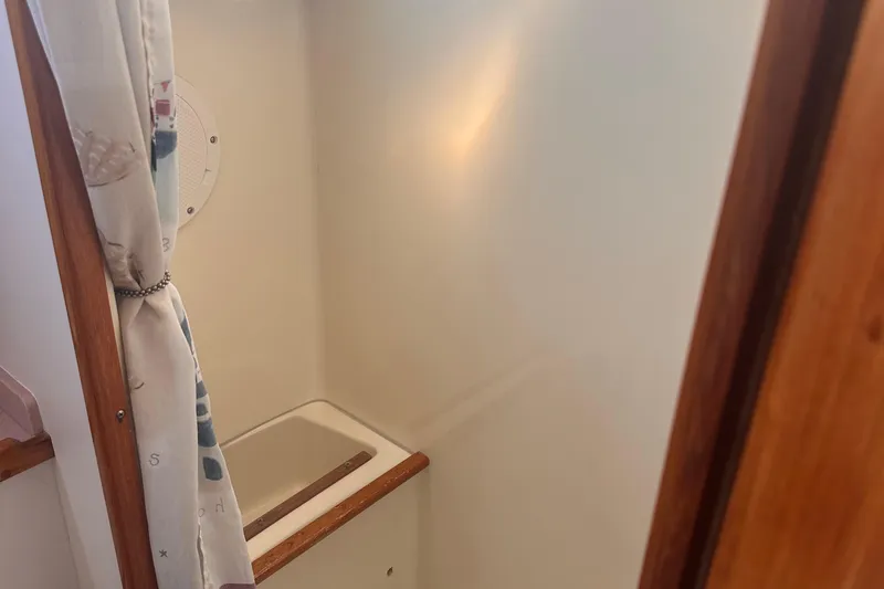 Slide: The Image of Interior of 1978 Pearson 424 sailboat, featuring a compact shower area with curtain. - 7
