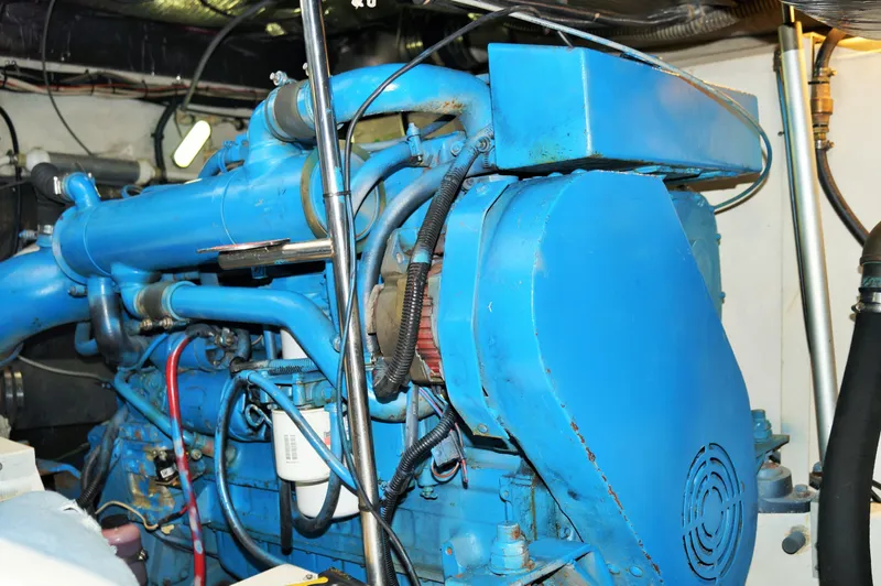 Slide: The Image of Engine room of a 1995 Tiara Yachts 4000 Express, featuring a blue marine engine. - 38