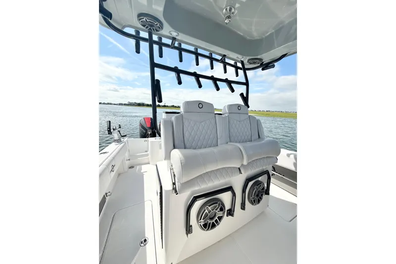 Slide: The Image of 2024 Fountain 34 TE boat interior with luxury seating and rod holders on a sunny day. - 13