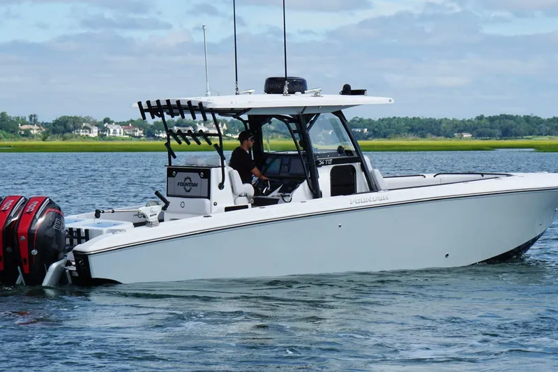 Slide: The Image of 2024 Fountain 34 TE boat cruising on a calm lake with dual engines. - 3