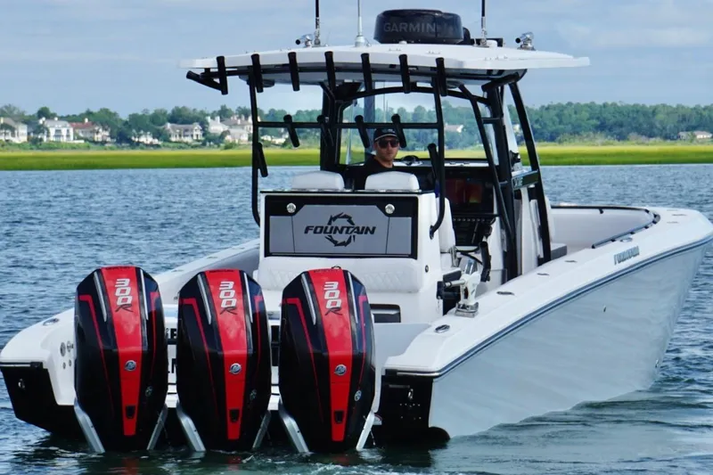 Slide: The Image of 2024 Fountain 34 TE boat with triple 300R engines on a scenic waterway. - 5