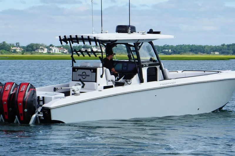 Slide: The Image of 2024 Fountain 34 TE boat cruising on a calm lake with twin outboard engines. - 9