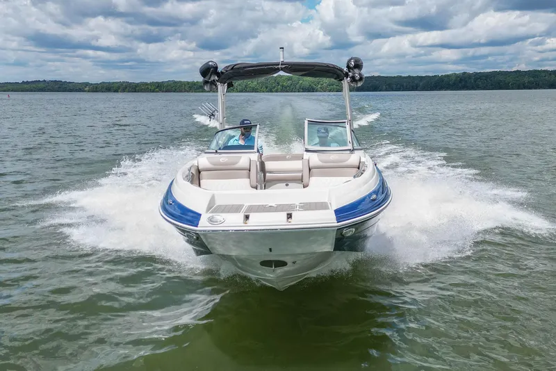 Slide: The Image of 2019 Crownline Eclipse E255 SURF boat cruising on a lake under a cloudy sky. - 10