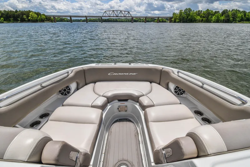 Slide: The Image of 2019 Crownline Eclipse E255 SURF boat interior with plush seating on a scenic lake. - 11