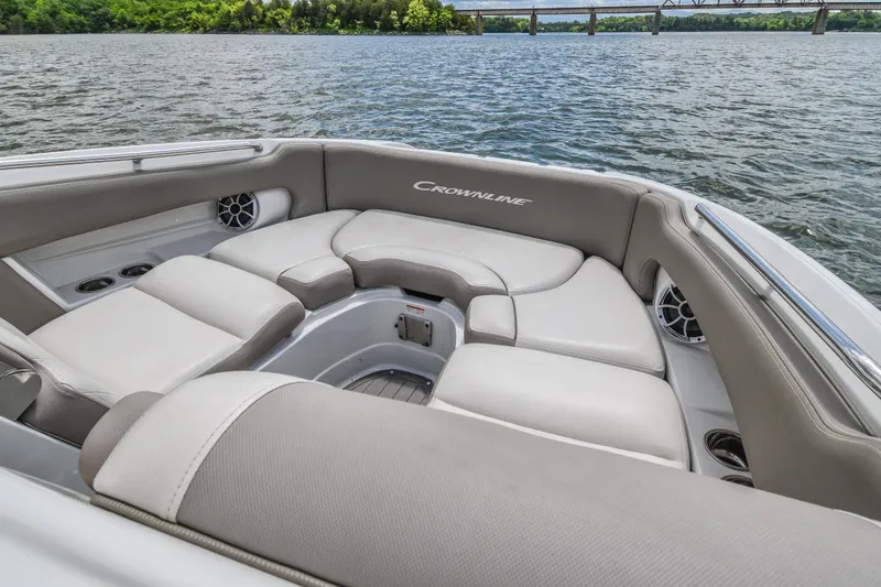 Slide: The Image of 2019 Crownline Eclipse E255 SURF boat interior with plush seating on a scenic lake. - 12