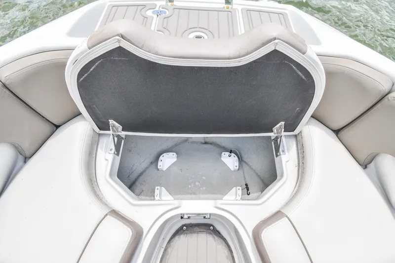 Slide: The Image of 2019 Crownline Eclipse E255 SURF boat storage compartment open, showing interior space. - 13