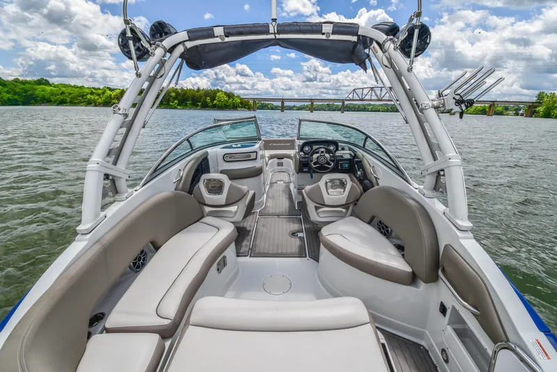 Slide: The Image of 2019 Crownline Eclipse E255 SURF boat interior on a scenic lake with bridge view. - 16