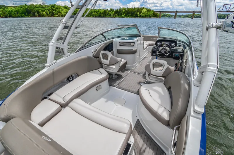 Slide: The Image of 2019 Crownline Eclipse E255 SURF boat interior with seating and steering wheel on a lake. - 17